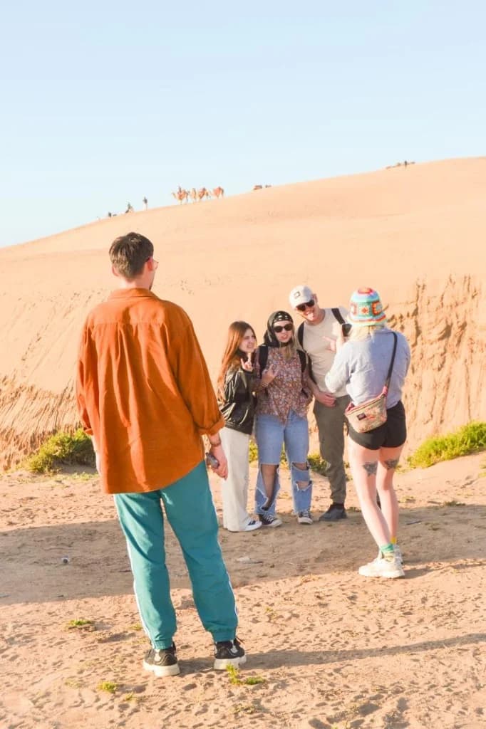 Guests together at the dunes at golden hour on an organised trip.
